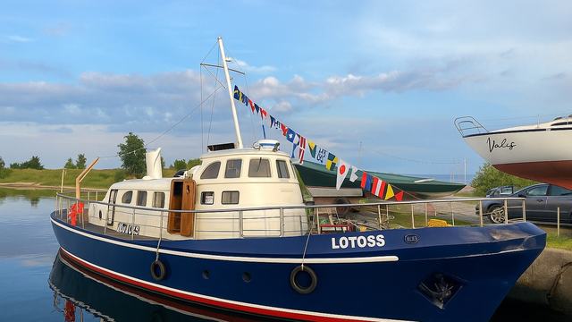 M/V LOTOSS alongside after dry dock, freshly painted and dressed overall with signal flags.